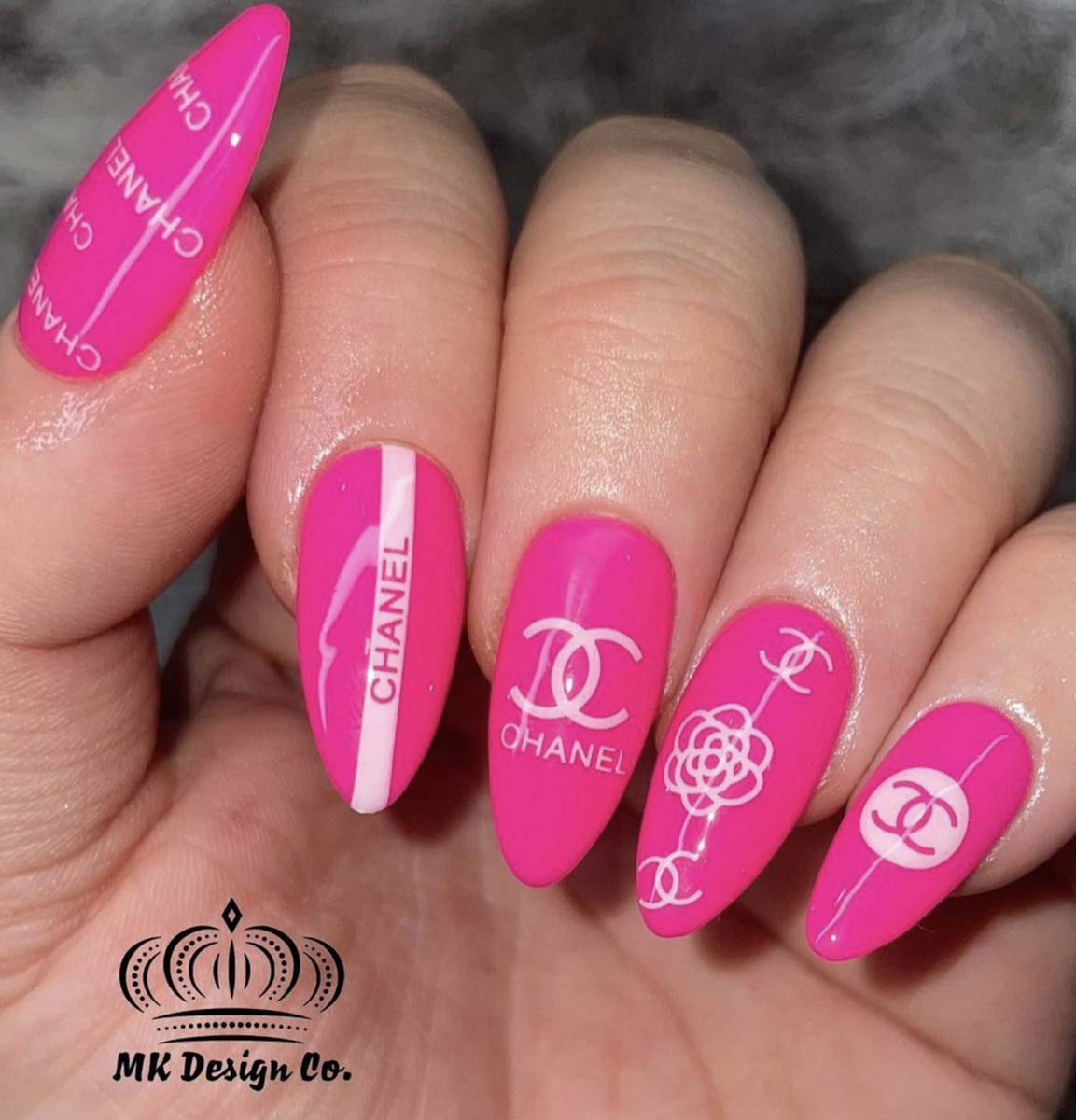 Unghie rosa acceso con logo Chanel