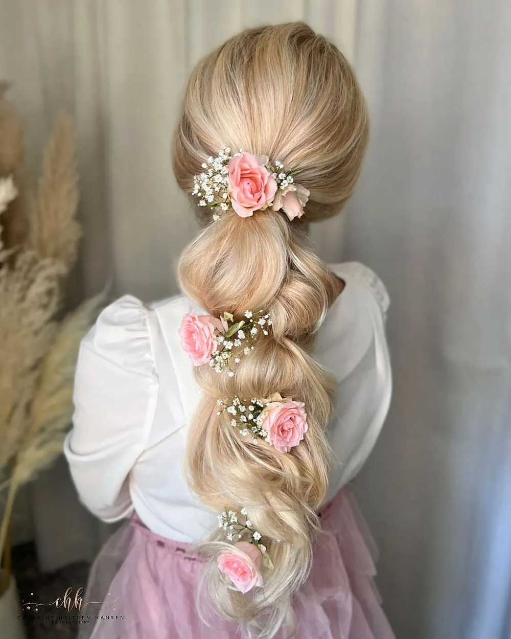 Capelli raccolti con fiori rosa