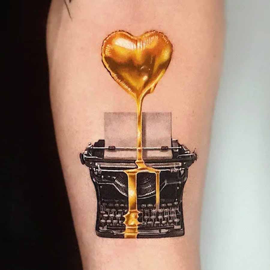 Tatuaggio cuore oro e macchina da scrivere