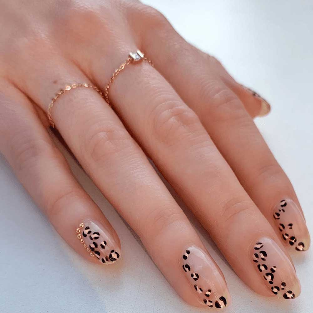 unghie con piccole stampe leopardate nero e oro