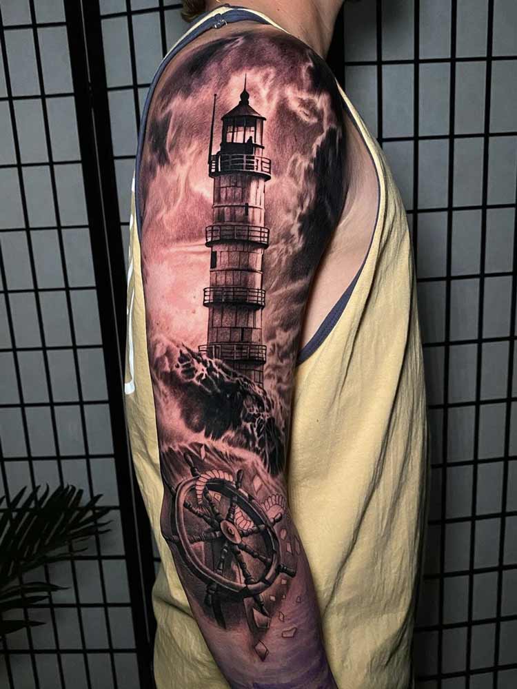 Tatuaggio faro con timone su tutto il braccio