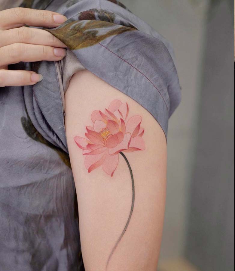 Tatuaggio con dettagli fiori di Loto sulla spalla