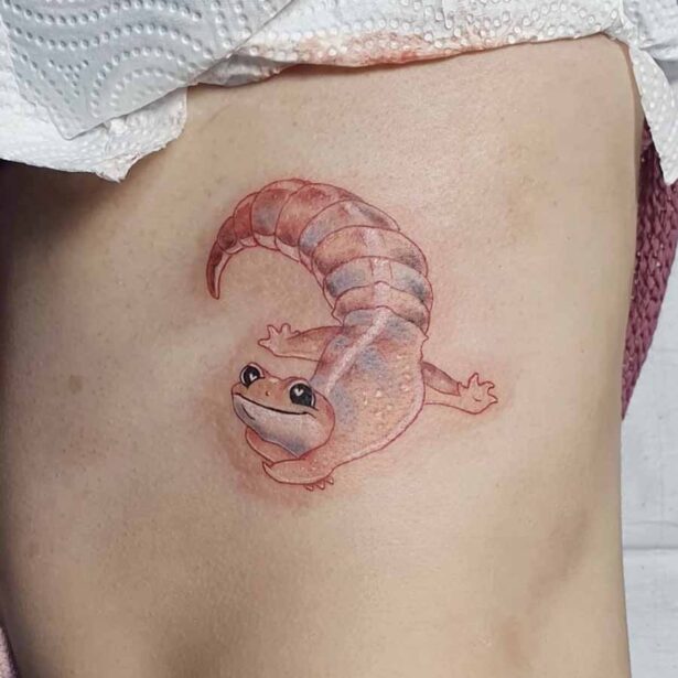 Tatuaggio piccolo colorato di un geco rilassato